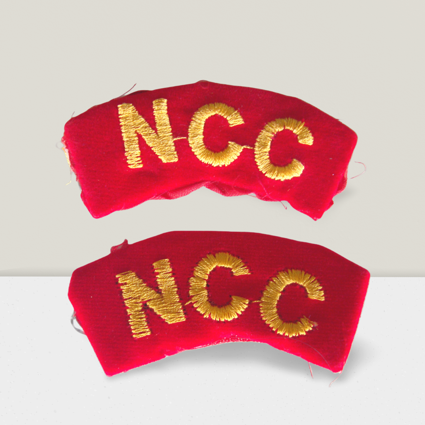NCC Army shoulder arm title badge set with gold embroidered ‘NCC’ text on red fabric, curved design for cadet uniform, suitable for boys and girls.