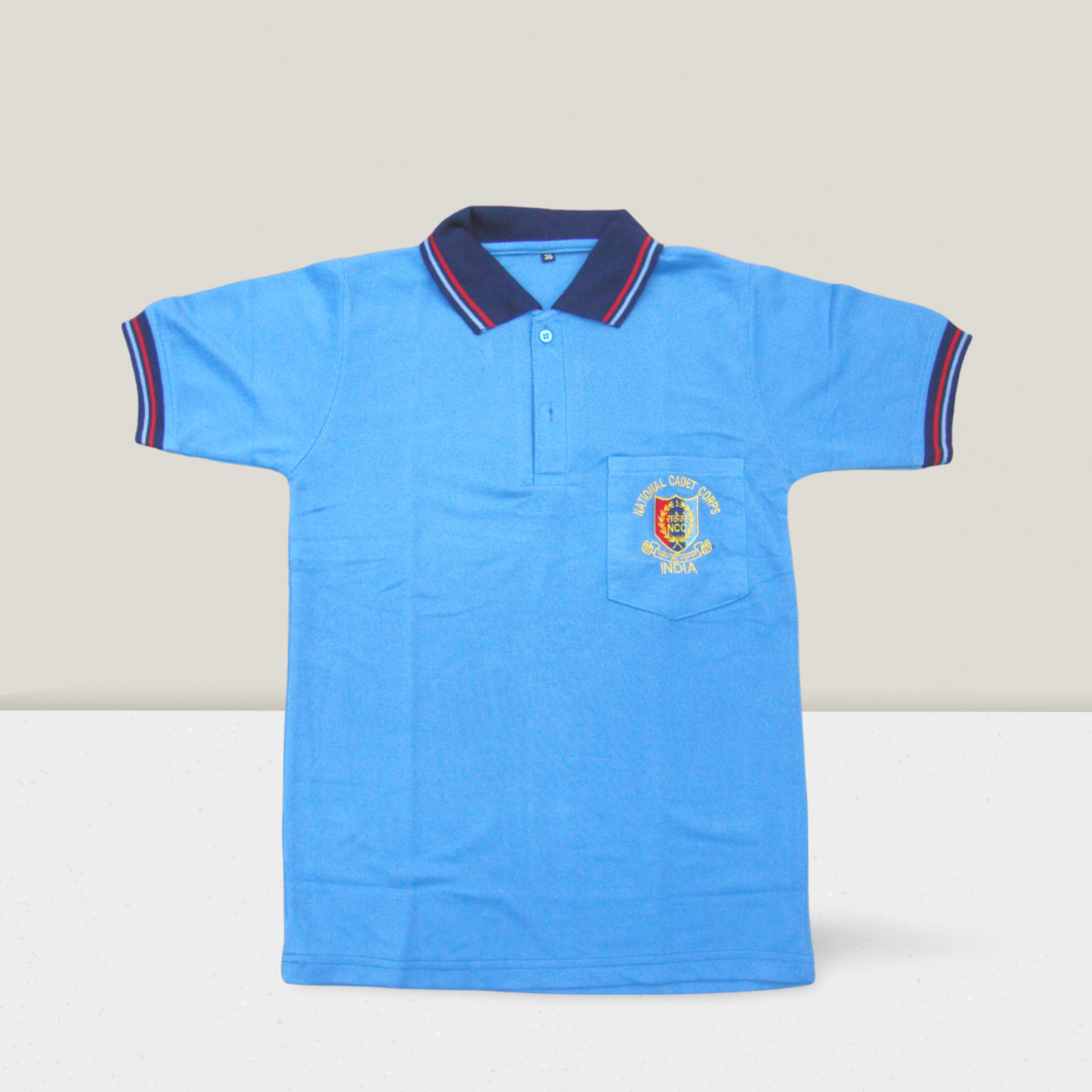 Sky-blue NCC cadet unisex polo T-shirt for boys and girls with embroidered logo pocket, featuring striped collar and sleeve cuffs, front button placket, and accessibility-focused product display.